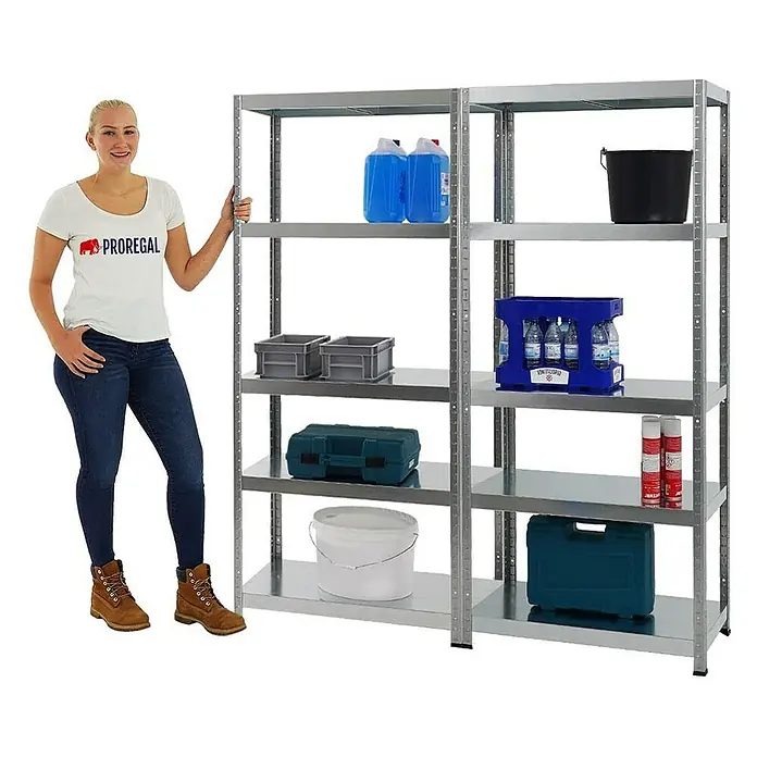 Proregal Metallregal Mega Deal Steel Eagle - Traglast pro Boden: 130 kg, Anzahl Böden: 5 Stk., Stecken, Verzinkt - Silbernes Metallregal mit fünf Regalböden, beladen mit verschiedenen Gegenständen, neben einer Frau.