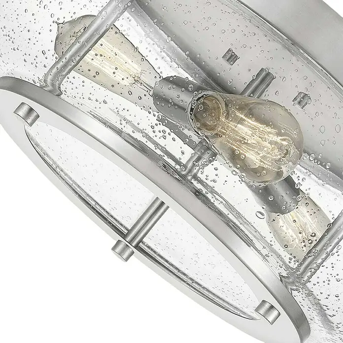 Elstead Deckenleuchte Trilogy - 60 W, L x B x H: 40,6 x 40,6 x 18 cm, Nickel, E27 - Nahaufnahme einer modernen Deckenleuchte mit klarem, strukturiertem Glas und Edison-Glühbirnen, die ein warmes Licht ausstrahlen.