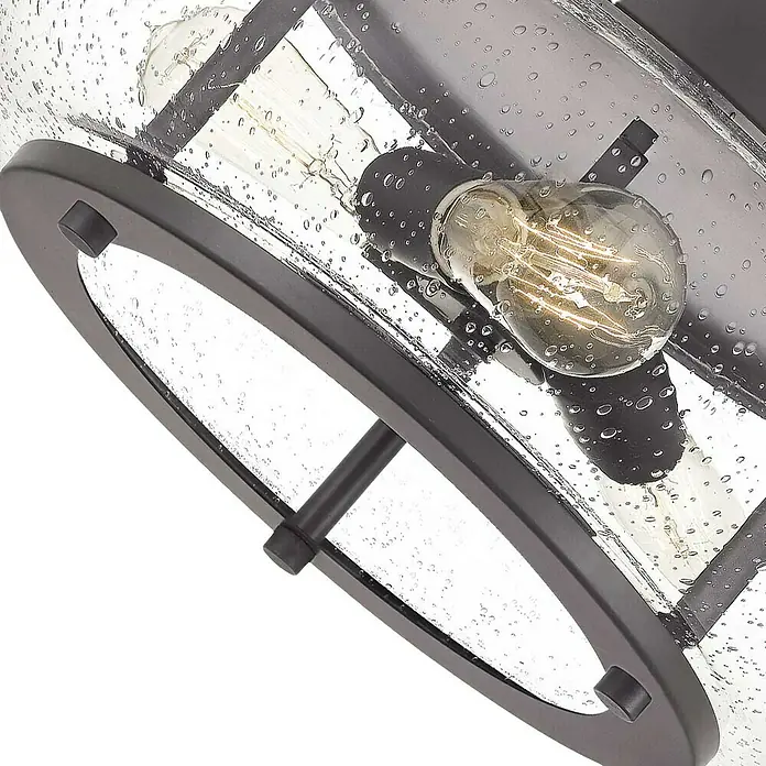 Elstead Deckenleuchte Trilogy - 60 W, L x B x H: 40,6 x 40,6 x 18 cm, Altbronze, E27 - Nahaufnahme einer Deckenleuchte mit Industrie-Design und einer klaren Glasabdeckung mit Wassertropfen-Effekt und dekorativer Glühbirne.