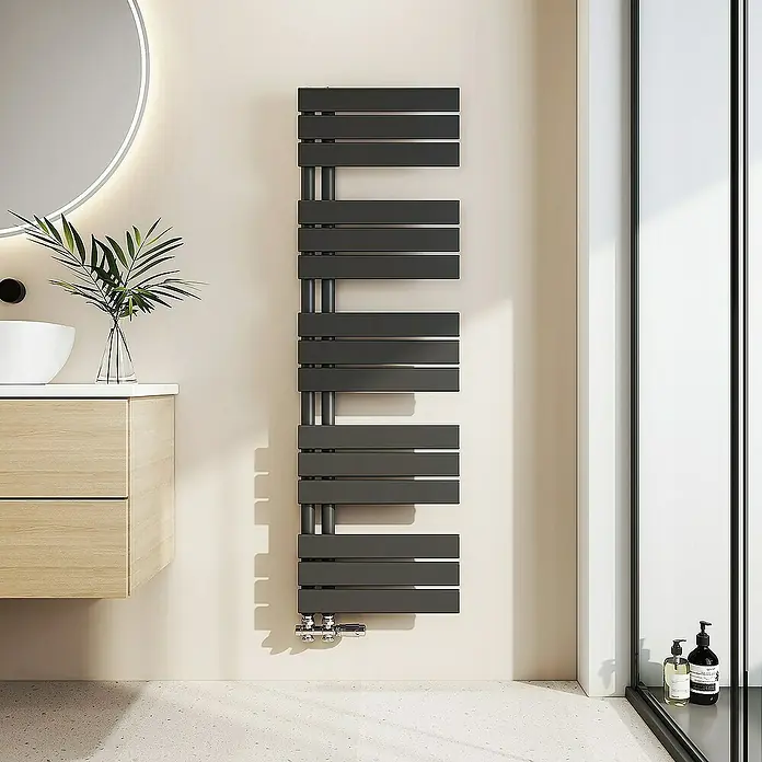 Emke Badheizkörper Flachrohr Handtuchwärmer Heatra - B x H: 40 x 132 cm, Schwarz - Ein moderner, grauer Handtuchwärmer hängt an der Wand eines Badezimmers mit minimalistischem Design. Er sorgt für warme Handtücher nach dem Duschen.
