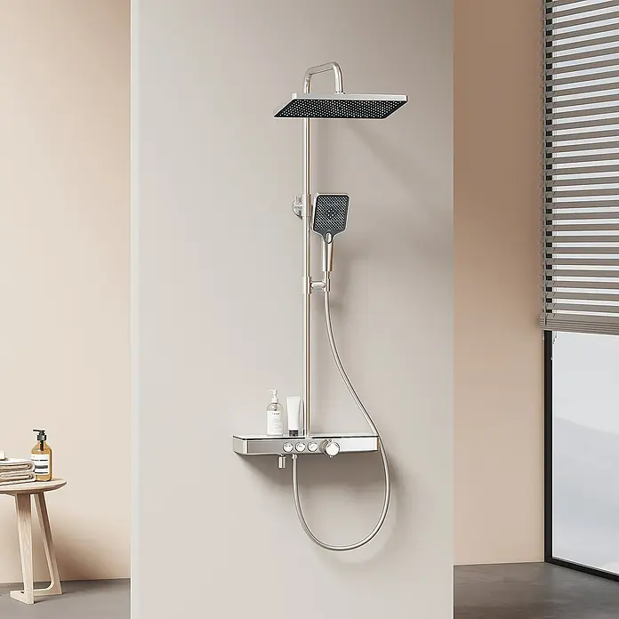 Emke Duschsystem Tastenschalter Duschsäule F10 - Mit Thermostatarmatur, Lochabstand: 72,6 cm, Anzahl Strahlarten: 3 Stk., Chrom - Bild einer modernen Duschgarnitur mit quadratischem Kopf und Handbrause, montiert an einer beigen Wand im Badezimmer.