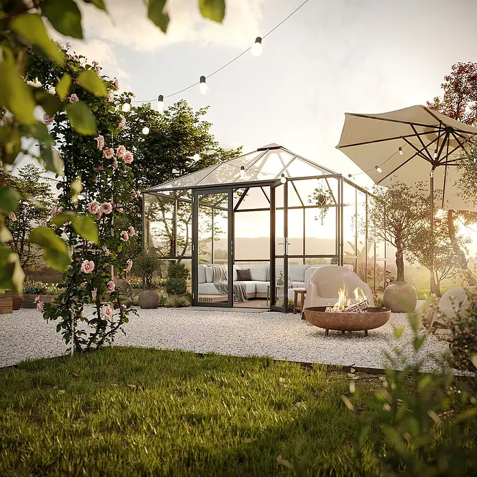 KGT Gewächshaus PaviLux 3,5 - Außenmaß inkl. Dachüberstand (B x T): 350 x 350 cm, 4 mm, Anthrazit-grau, Einscheibensicherheitsglas - Einladender Garten mit Gewächshaus, Lichterketten und Feuerstelle. Das Gewächshaus bietet eine gemütliche Sitzecke.