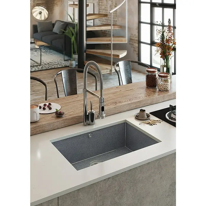 Atron Fregadero encastrable Magma - 48,5 x 59,5 cm, Material compuesto, Negro, Mate - Primer plano de un fregadero de cocina moderno con grifo, empotrado en una encimera luminosa. Detalles de espacio habitable difuminados al fondo.
