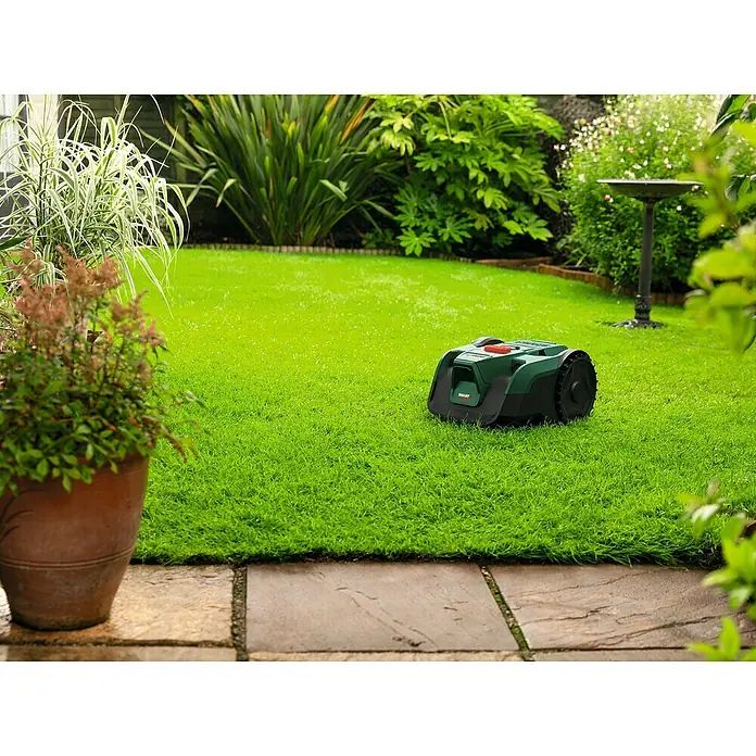 Bosch Power for All 18V Mähroboter VISIMOW 18V-100 - 100 m², Schnittbreite: 16 cm, Kamera-gestützte Navigation, Ultraschallsensorik, Ohne Akku - Ein grüner Mähroboter auf einem gepflegten Rasen in einem üppigen Garten. Der Rasenmäher ist bereit, die Rasenpflege zu automatisieren.