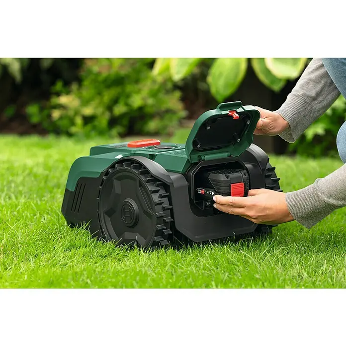 Bosch Power for All 18V Mähroboter VISIMOW 18V-100 - 100 m², Schnittbreite: 16 cm, Kamera-gestützte Navigation, Ultraschallsensorik, Ohne Akku - Der Bosch Mähroboter Indego im Einsatz, mit einer Person, die den Akku wechselt. Perfekt für einen gepflegten Rasen.