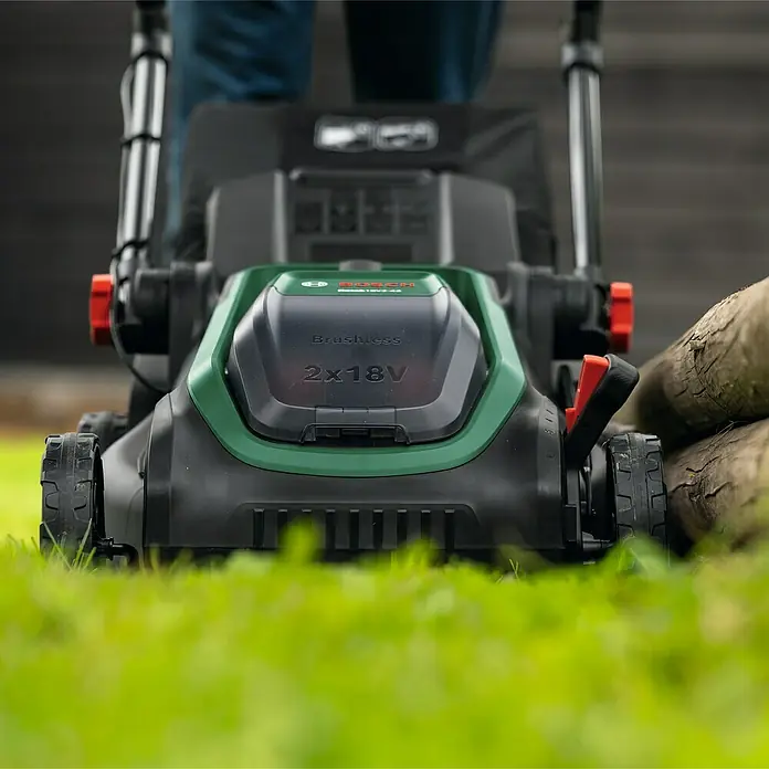 Bosch Power for All 18V Akku-Rasenmäher ROTAK18V2-43 - Ohne Akku, Schnittbreite: 43 cm - Nahaufnahme eines Bosch Rotak 2x18V-43 Akku-Rasenmähers, der auf Rasen steht und für präzise und kabellose Rasenpflege sorgt.