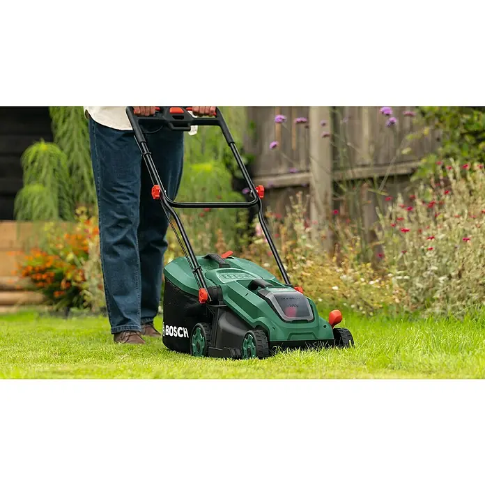 Bosch Power for All 18V Akku-Rasenmäher ROTAK18V-34 - Ohne Akku, Schnittbreite: 34 cm - Ein grüner Bosch Akku-Rasenmäher wird von einer Person im Garten benutzt, um den Rasen zu mähen. Der Rasenmäher hat einen Grasfangkorb.