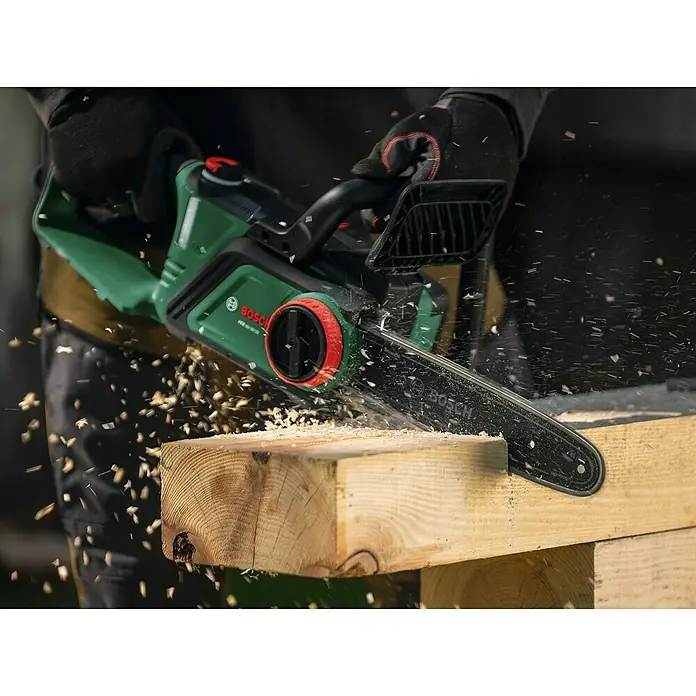 Bosch Power for All 18V Akku-Kettensäge PKE18V-30-28 - 18 V, 4 Ah, Li-Ionen, 1 Akku, Schwertlänge: 30 cm - Nahaufnahme einer Bosch Kettensäge beim Zersägen eines Holzstücks, Späne fliegen.