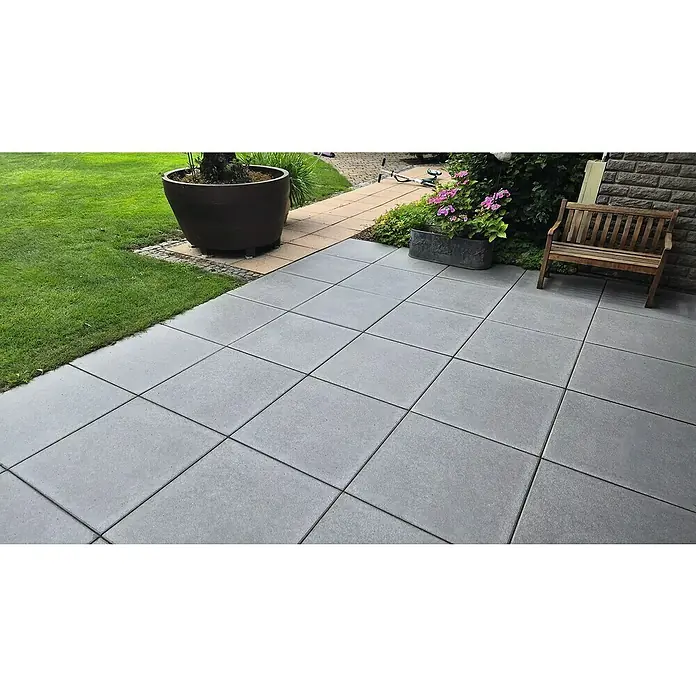 Diephaus Terrassenplatte Redding - 60 x 60 x 4 cm, Quarz, Beton - Eine gepflasterte Terrasse mit großen grauen Betonplatten, die einen modernen und pflegeleichten Außenbereich schaffen.\n