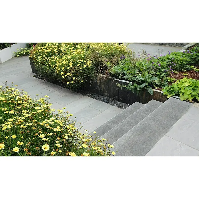 Diephaus Winkelstufe - 80 x 32 x 18 cm, Grau, Beton - Eine Außenaufnahme mit grauen Pflastersteinen und einer Steintreppe, umgeben von blühenden gelben und lila Blumen.