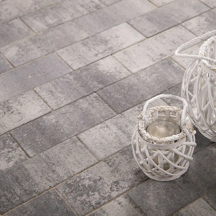 EHL EIBA Pflasterstein - 30 x 13,3 x 6 cm, Grau-Anthrazit, Beton - Nahaufnahme von zwei dekorativen weißen Laternen auf einem gepflasterten Weg, die eine gemütliche Atmosphäre für den Außenbereich schaffen.