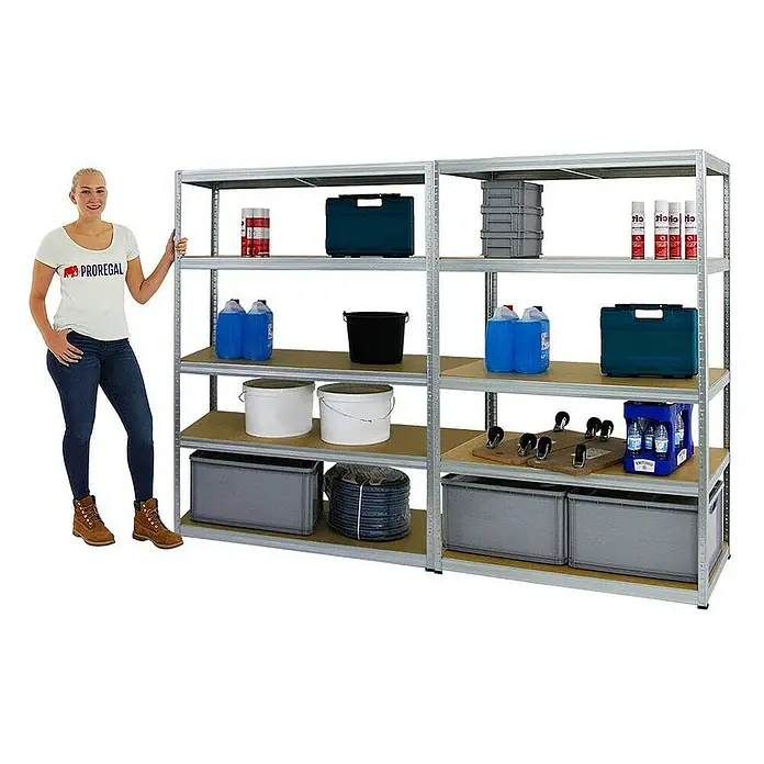 Proregal Schwerlastregal Mega Deal Big Elephant M - H x B x T: 180 x 120 x 60 cm, Traglast pro Boden: 250 kg, Anzahl Böden: 5 Stk., Stecken, Verzinkt - Eine Frau steht neben einem Regal voller Lagerartikel, darunter Behälter, Farbeimer und Reinigungsmittel. Das Regal ist aus Metall gefertigt.