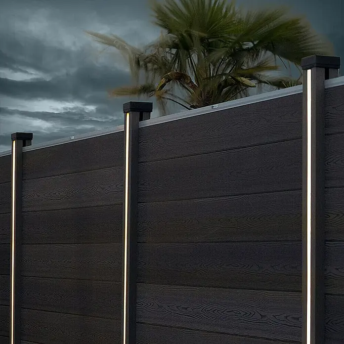 Home Deluxe Zaunabschlussleiste CALLUX inkl. LED Beleuchtung 1er Set -  - Nahaufnahme eines modernen Holzzauns mit integrierter LED-Beleuchtung, die eine warme Atmosphäre schafft.