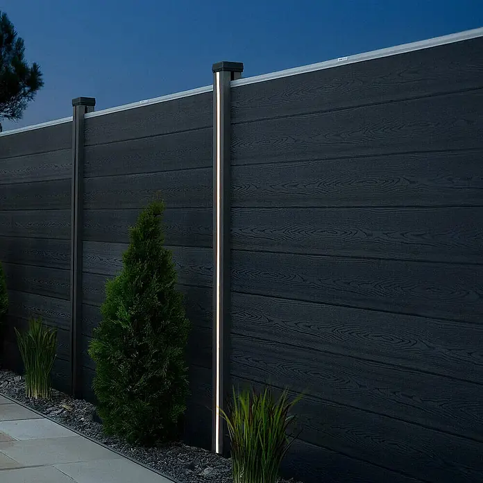 Home Deluxe Zaunabschlussleiste CALLUX inkl. LED Beleuchtung 6er Set -  - Ein modernes schwarzes Gartenzaun-System mit integrierter Beleuchtung, umgeben von Pflanzen.