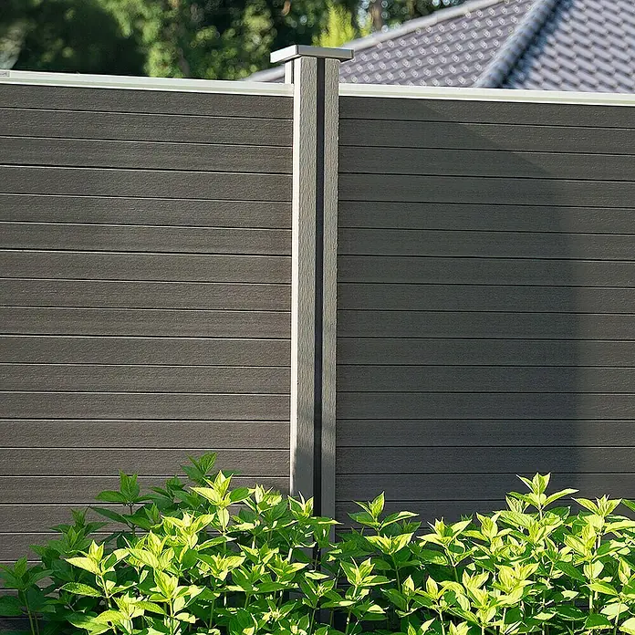 Home Deluxe Zaunabschlussleiste DINA - 2er Set -  - Nahaufnahme eines modernen, grauen WPC-Sichtschutzzauns mit Pflanzen im Vordergrund, ideal für Garten und Terrasse.