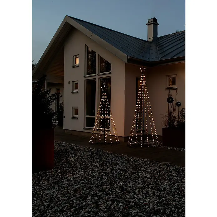 Konstsmide LED-Weihnachtsleuchte Tannenbaum - Höhe: 240 cm, Anzahl Leuchtmittel: 665 Stk. - Stimmungsvolle Außenansicht eines Hauses mit zwei leuchtenden Weihnachtsbaum-Dekorationen, die eine festliche Atmosphäre verbreiten.