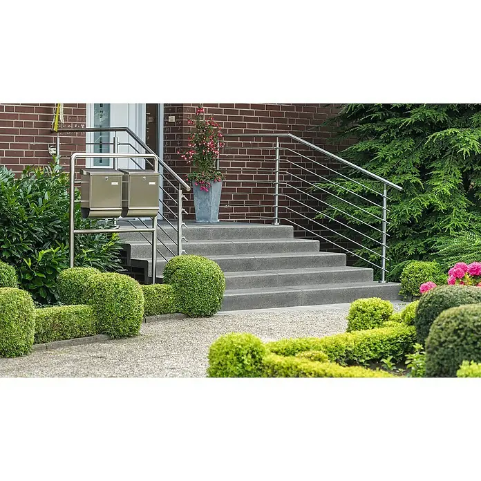 Diephaus Winkelstufe - 90 x 32 x 18 cm, Grau, Beton - Eingangsbereich eines Hauses mit einer Treppe, Edelstahlgeländer, Briefkästen und ordentlich geschnittenen Büschen.