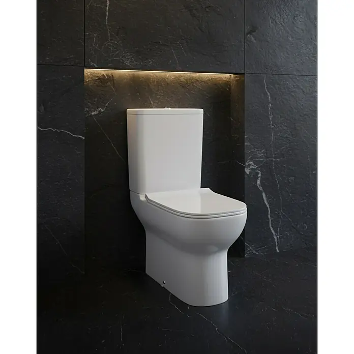 Camargue Pack de WC Oslo - Sin borde de descarga, Blanco - Inodoro moderno de cerámica blanca sobre una pared de mármol oscuro con iluminación indirecta. Diseño elegante para un baño con estilo.