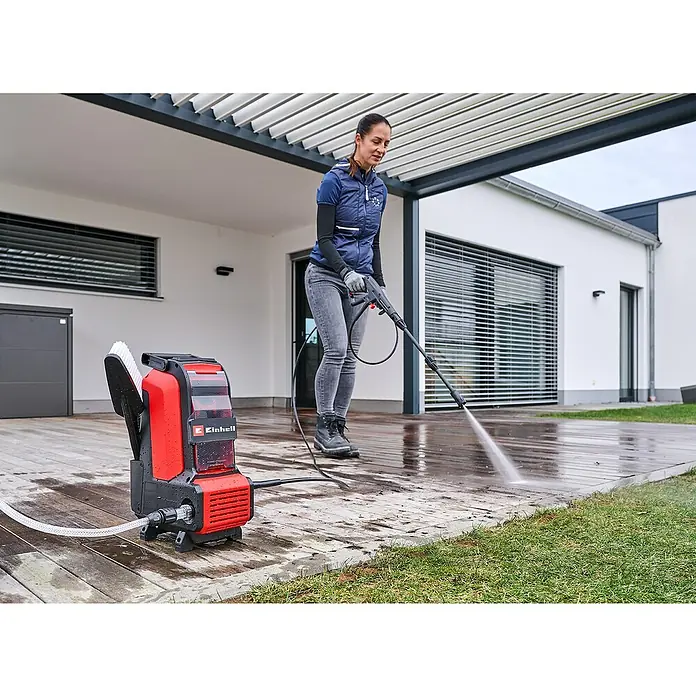 Einhell Power X-Change 18V Akku-Hochdruckreiniger Hypresso 36/105 - 36 V, Ohne Akku - Frau reinigt mit dem Einhell Akku-Hochdruckreiniger ihre Terrasse. Kompaktes, rotes Gerät für den mobilen Einsatz im Außenbereich.