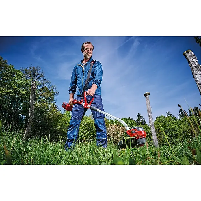 Einhell Professional Akku-Rasentrimmer GP-CT 36/35 Li BL - 36 V, Li-Ionen, Ohne Akku, Schnittbreite Faden: 35 cm - Ein Mann mit einer roten Akku-Motorsense im Garten. Das Gerät erleichtert die Gartenarbeit und sorgt für präzise Ergebnisse.