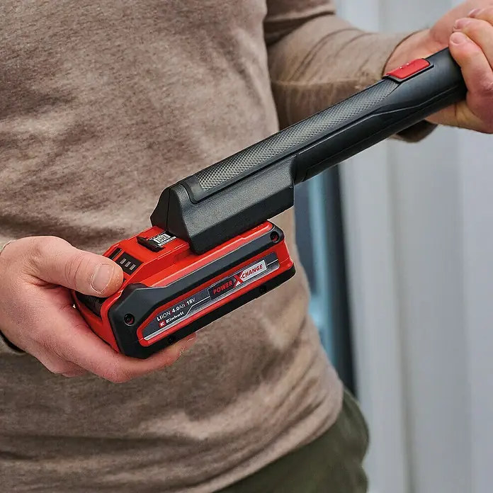 Einhell Teleskopstange Brillianto - Kunststoff, 2 -tlg., Auszugslänge: 120 cm - Nahaufnahme einer Einhell Power X-Change Akku-betriebenen Lampe, die die rote und schwarze Batterie und das ergonomische Design hervorhebt.