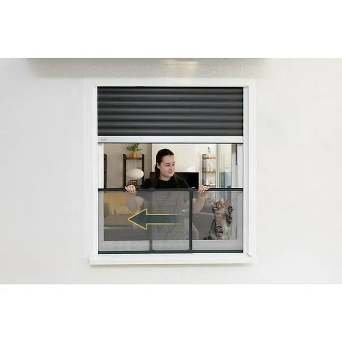 Schellenberg Mosquitera - 75 cm - 142 cm, Inserción, Color bastidor: Antracita - Una mujer abre una ventana con mosquitera, mientras un gato observa con curiosidad. La mosquitera protege de los insectos y deja entrar aire fresco.