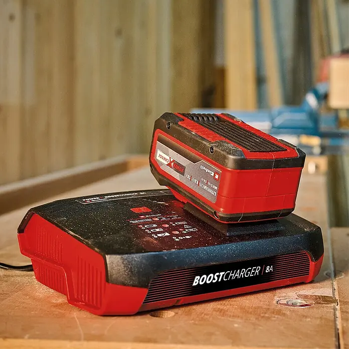 Einhell Power X-Change 18V Akku-Ladegerät Power X-Boostcharger 8A - Ladespannung: 18 V - Akku und Ladegerät der Marke Einhell. Das Ladegerät ist schwarz und rot, der Akku ist oben auf dem Ladegerät platziert.