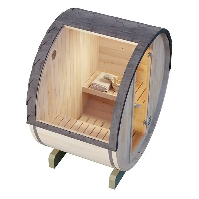 FinnTherm Fasssauna Comfort Set Mini XXS - Elektroofen, Holz - Hier ist eine Fasssauna. Sie ist aus hellem Holz gefertigt, hat eine Tür und ein kleines Fenster. Das Dach ist mit dunklen Schindeln gedeckt.