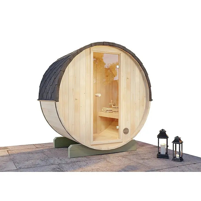 FinnTherm Fasssauna Comfort Set Mini XXS - Elektroofen, Holz - Fasssauna mit gläserner Tür und dekorativen Laternen. Die Sauna steht auf einem Steinsockel und ist von aussen beleuchtet.