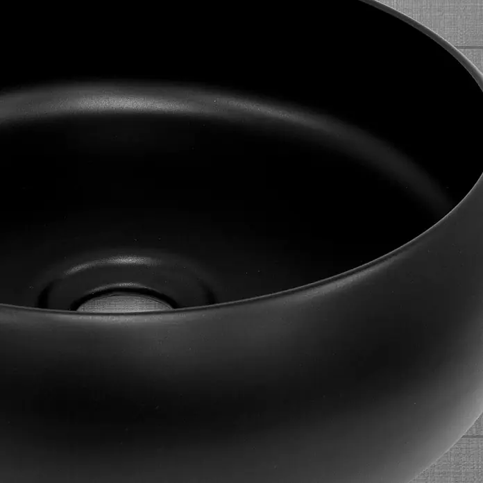LuxeBath Aufsatzwaschbecken Rund Ø35x12 cm Schwarz Ablaufgarnitur Schwarz - Ohne Spezialglasur, Schwarz - Nahaufnahme eines schwarzen, runden Waschbeckens mit glatter Oberfläche und einem Abflussloch.