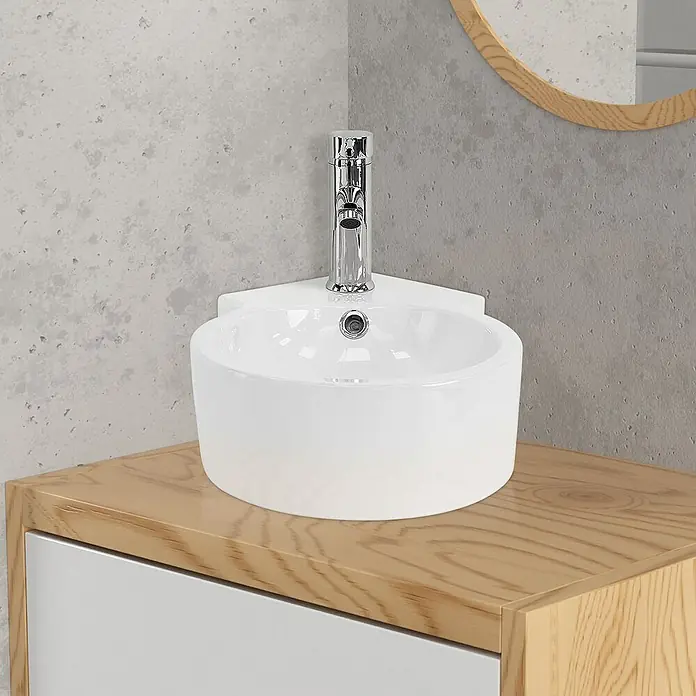 LuxeBath Aufsatzwaschbecken Eckwaschbecken Rund 45x36x13 cm Weiß Ablaufgarnitur Weiß Überlauf - Ohne Spezialglasur, Weiß, Silber - Ein modernes Waschbecken mit Armatur, montiert auf einem hellen Holzunterschrank mit weißer Tür, ideal für ein stilvolles Badezimmer.