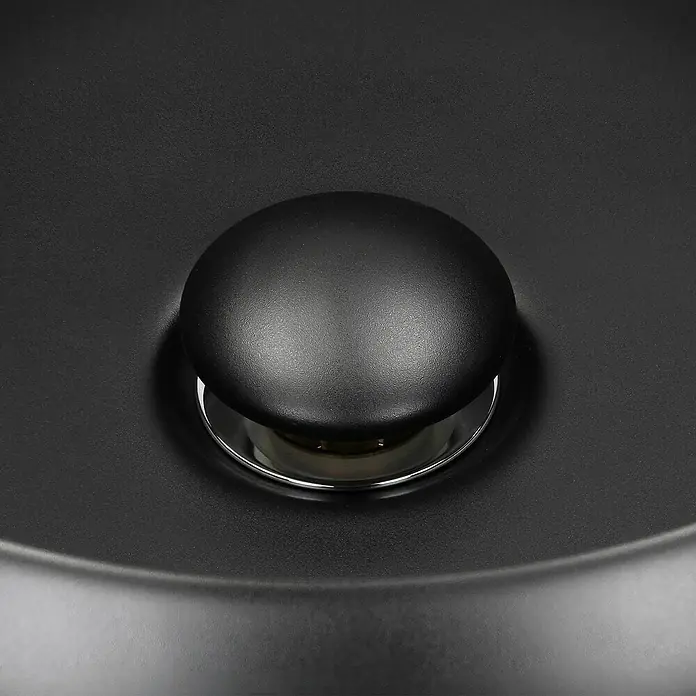 LuxeBath Aufsatzwaschbecken Handwaschbecken Schwarz inkl. Ablaufgarnitur mit Überlauf - Ohne Spezialglasur, Schwarz - Nahaufnahme eines schwarzen Waschbeckenstöpsels aus Keramik mit glänzenden Chromdetails.