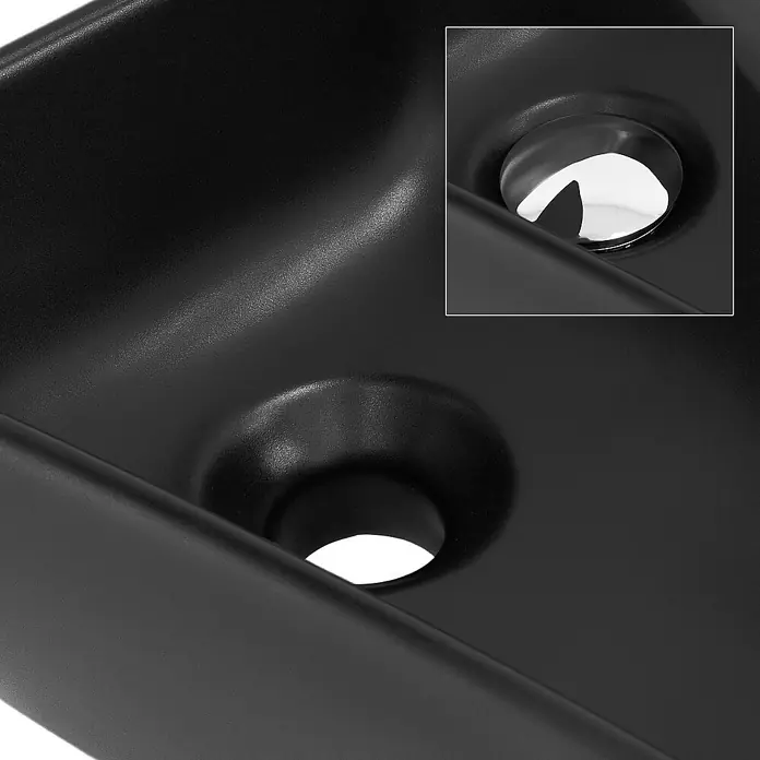 LuxeBath Aufsatzwaschbecken Handwaschbecken Schwarz inkl. Ablaufgarnitur mit Überlauf - 27 x 45 cm, Ohne Spezialglasur, Schwarz, Silber - Nahaufnahme eines modernen, schwarzen Waschbeckens mit glänzendem, rundem Abflussstopfen und minimalistischem Design für Badezimmer.