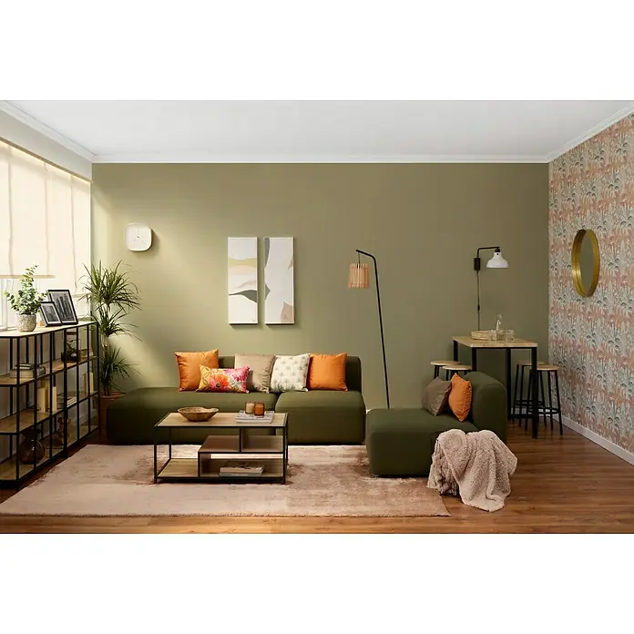 Papel pintado Botánico Palmeras - Beige, Floral, 10 x 0,53 m - Acogedora sala de estar con sofá verde oliva, mesa de centro y estanterías. Cojines decorativos y lámparas crean un ambiente acogedor.