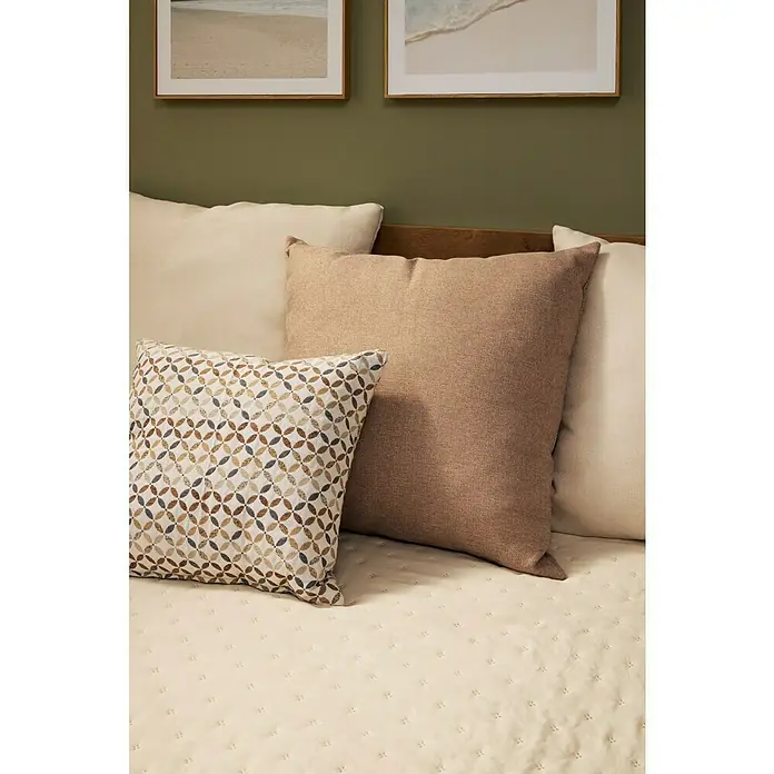 Cuadro Agua Playa - An x Al: 40 x 40 cm, 1 pzs. - Una disposición de almohadas decorativas en una cama, incluyendo una almohada estampada, una almohada beige y una almohada blanquecina.