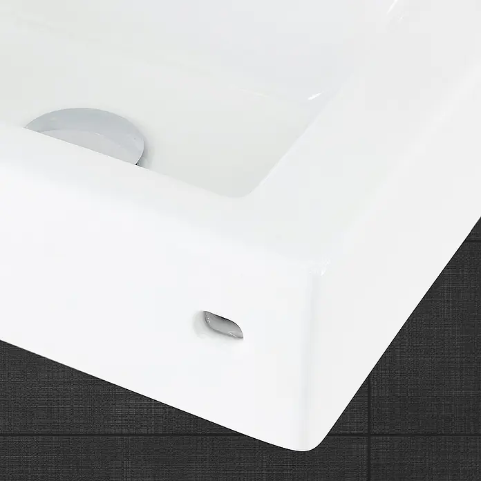 LuxeBath Aufsatzwaschbecken Waschtisch aus Keramik für Badezimmer / Gäste-WC - 26 x 46 cm, Ohne Spezialglasur, Weiß - Nahaufnahme eines weißen Waschbeckens mit Überlauf und Abfluss auf dunklem Fliesenhintergrund.