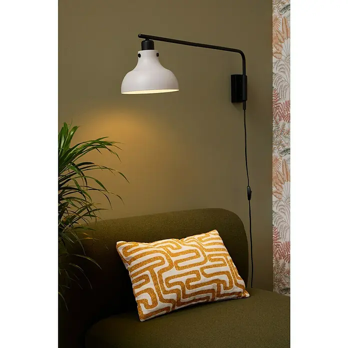 Eglo Matlock Aplique de pared - 40 W, L x Al: 20 x 25 cm, Gris, E27 - Primer plano de una lámpara de pared blanca moderna con brazo negro, que proyecta una luz cálida sobre un sofá verde con almohada amarilla.