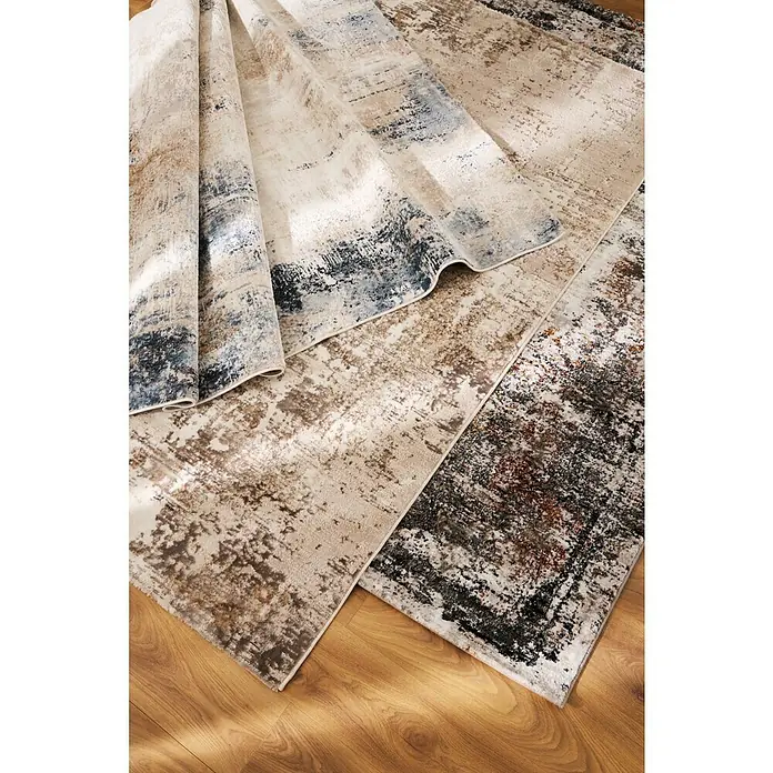 Alfombra de pelo corto Hermes - Azul, 190 x 135 cm, 100% Poliéster - Una fotografía detallada que muestra una alfombra con un estampado abstracto con tonos beige, marrones y azules.