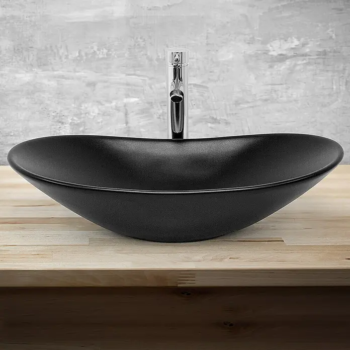 LuxeBath Aufsatzwaschbecken Waschtisch aus Keramik für Badezimmer / Gäste-WC - Ohne Spezialglasur, Schwarz - Schwarzes Aufsatzwaschbecken mit schlankem Chromhahn auf einer hellen Holzplatte vor einer grauen Wand.