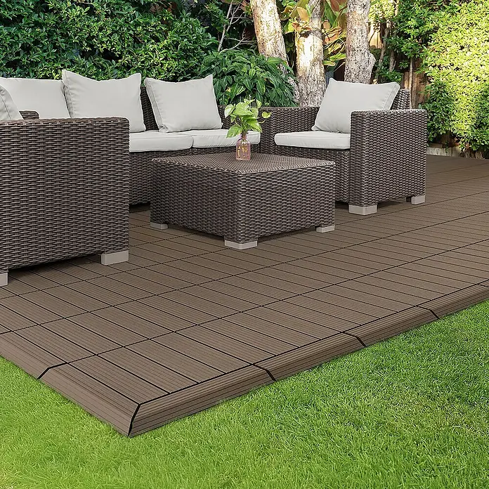ML-Design Terrassenfliese - 7,5 cm x 30 cm x 20 mm, Dunkelbraun - Das Bild zeigt eine stilvolle Terrassengestaltung mit braunen Bodenfliesen, einer Sitzgruppe und Grünpflanzen im Hintergrund.