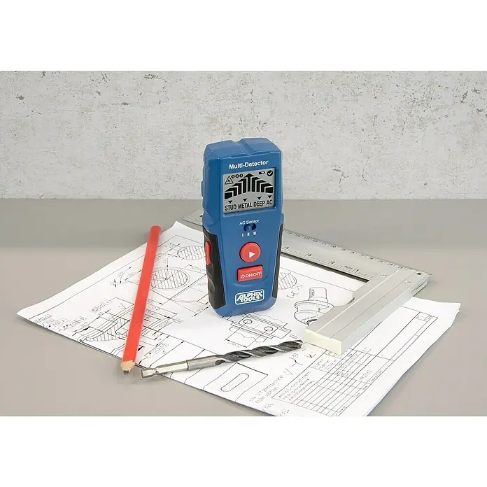 Alpha Tools Metall- & Holzsuchgerät Multi-Detektor - Betriebstemperatur: 0 °C - 40 °C - Das Bild zeigt einen blauen Alpha Tools Multi-Detektor, der auf Bauplänen mit Bleistift und Bohrer platziert ist.