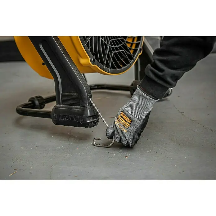DeWalt Bodenventilator DXF1645 - 110 W, Max. Luftleistung: 49,81 m³/h - Nahaufnahme eines gelben DeWalt Ventilators, bei dem eine Person mit Handschuhen einen Haken befestigt.