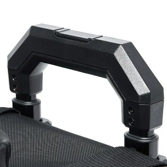 ToughBuilt Caja profesional con ruedas Massive Mouth® - 14'', L x An x Al: 455 x 370 x 500 mm - Primer plano de un asa de transporte negra y resistente fijada a una bolsa o equipo. El asa parece robusta y de diseño ergonómico.