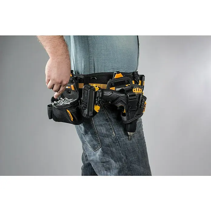 ToughBuilt ClipTech Soporte para taladro - L x An x Al: 150 x 110 x 190 mm - Primer plano de un hombre con cinturón de herramientas con taladro y tornillos, sobre un fondo neutro.
