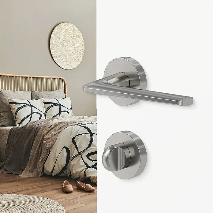 Diamond Doors Creative Drückergarnitur WC Roswell - Stärke Tür: 38 mm - 45 mm, Sonstiges, Samtgrau, Schlitzkopf/Olive - Nahaufnahme von Türdrücker und Drehknopf aus gebürstetem Stahl, montiert an einer weißen Tür.