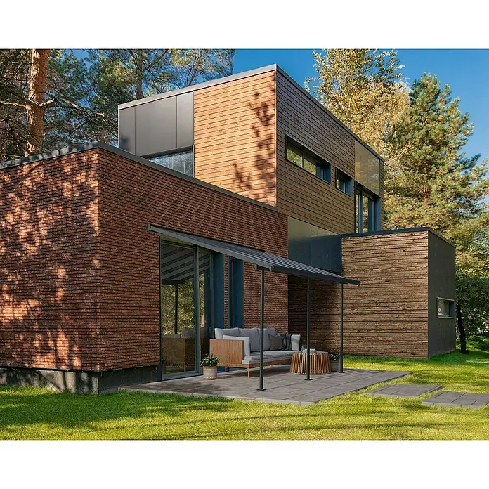 Palram – Canopia Terrassenüberdachung Sierra - B x T: 434 x 299 cm, Anthrazitgrau, Polycarbonat, Klar - Ein modernes Haus mit einer Fassade aus Ziegeln und Holz, das sich harmonisch in die natürliche Umgebung einfügt. Elegantes Design.