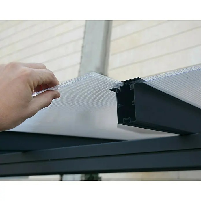 Palram – Canopia Terrassenüberdachung Sierra - B x T: 555 x 299 cm, Anthrazitgrau, Polycarbonat, Klar - Detailaufnahme einer Polycarbonatplatte, die in ein schwarzes Profil eingesetzt wird, Teil einer Terrassenüberdachung oder eines Carports.