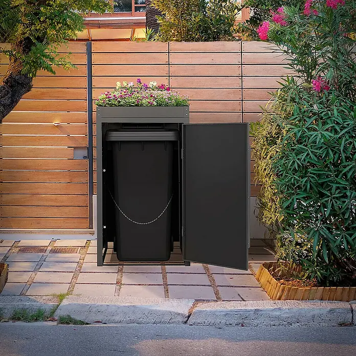 ML-Design Mülltonnenbox Mülltonnencontainer mit Pflanzdach für 1 Tonne 120 oder 240 Liter - Stahl, Eiche hell, Geeignet für Anzahl Mülltonnen: 1 Stk. - Das Bild zeigt einen grauen Mülltonnenbox mit Blumen auf dem Deckel, der eine schwarze Mülltonne enthält und eine offene Tür hat.