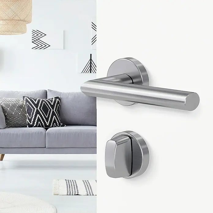 Diamond Doors Modern Drückergarnitur WC Detroit - Stärke Tür: 40 mm - 45 mm, Edelstahl, L-Form, Schlitzkopf/Olive - Türbeschlag aus Edelstahl mit Hebelgriff und Rosette vor modernem Wohnzimmerinterieur. Elegantes Design für zeitgemäße Inneneinrichtung.