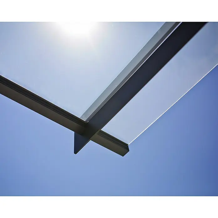 Palram – Canopia Pultvordach Nancy - 452 x 94 x 14 cm, Anthrazitgrau - Nahaufnahme eines modernen Glasdachs mit schlanken, anthrazitfarbenen Rahmen vor strahlend blauem Himmel, das Licht und architektonische Eleganz vereint.